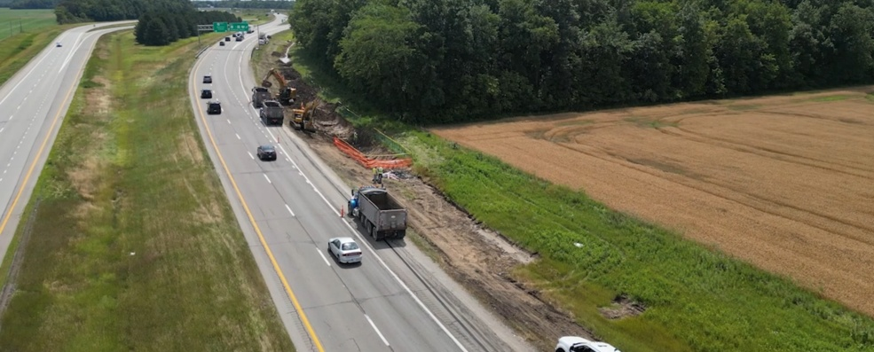 Aerial view of ERC excavators and dump trucks removing diesel-impacted soil along a highway shoulder during a tanker spill cleanup near Napoleon, Ohio